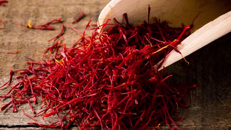 saffron threads with spice shovel on wooden background