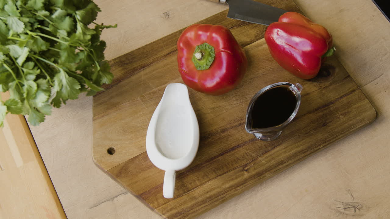 Red Bell Peppers, Herbs, and Sauces on a Cutting Board