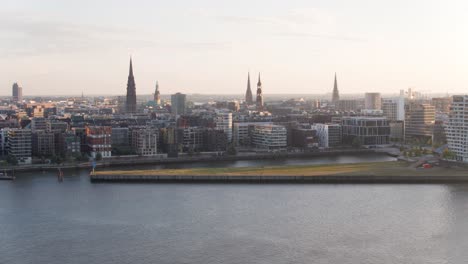 Drone-flight-over-Hamburg-on-a-sunny-summer-morning-from-the-habour-side-showing-the-new-Elbphilharmonie-house-the-michel-and-Landungsbrücken-in-the-Background