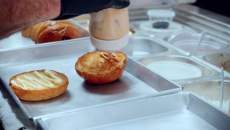 4k imágenes cinematográficas de cocina de un chef preparando y haciendo una deliciosa hamburguesa casera en la cocina de un restaurante en cámara lenta poniendo la salsa en los panes