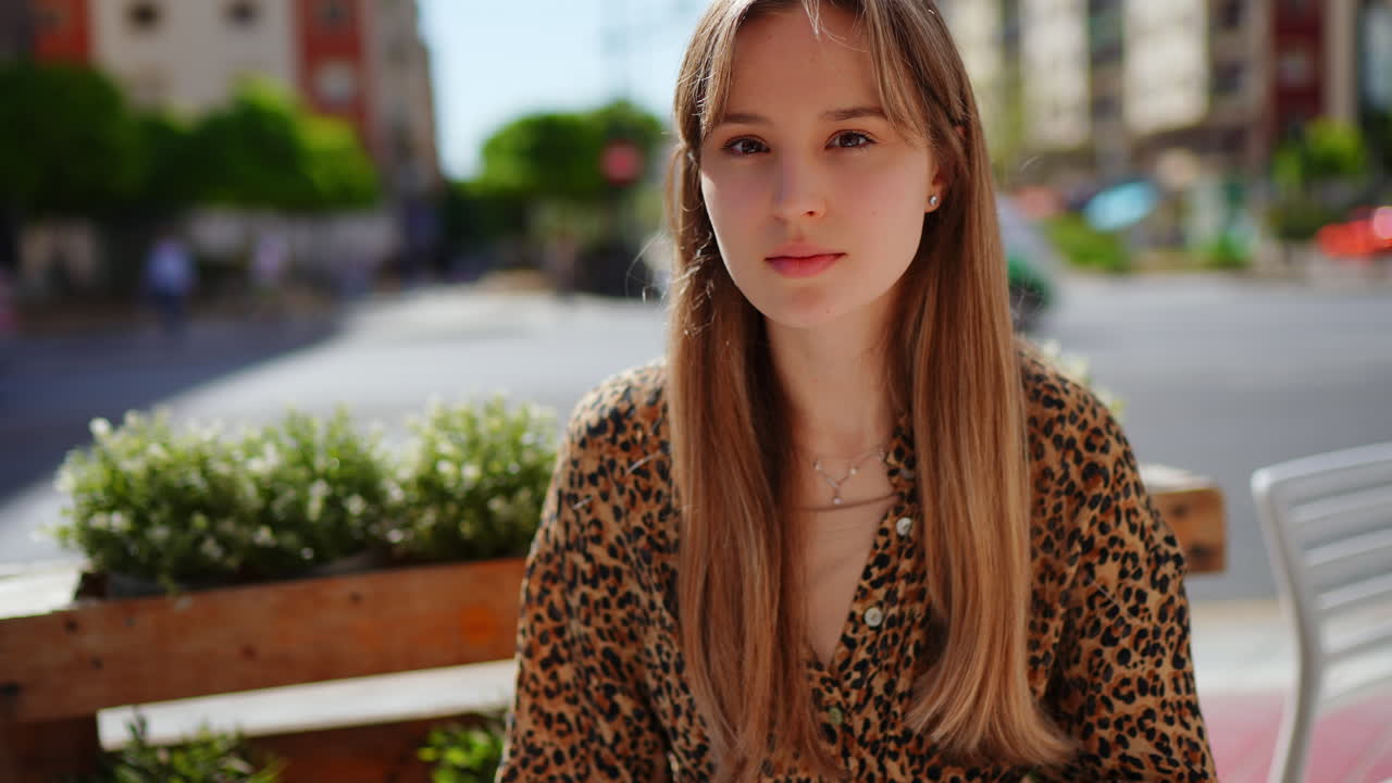 Ung kvinde, der sidder på en café