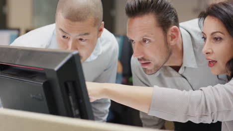 Woman-manager-leading-diverse-team-meeting-in-small-business.-Three-people-working-around-computer-late-at-night