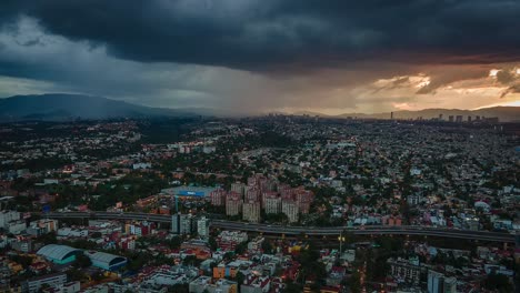 vista aérea de drones de nubes oscuras moviéndose sobre una carretera y el paisaje urbano, durante la puesta de sol, en la ciudad de méxico, américa - reversa, seguimiento, tiro de hiperlapso