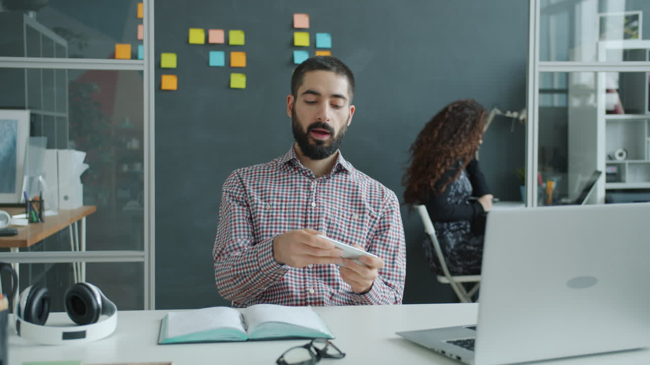 Business Person Checking Smartphone in Office