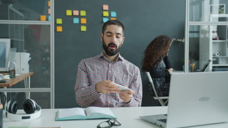 business person checking smartphone in office