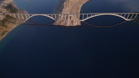 Reveal-shot-of-double-arch-bridge-Krk-in-Adriatic-sea,-aerial