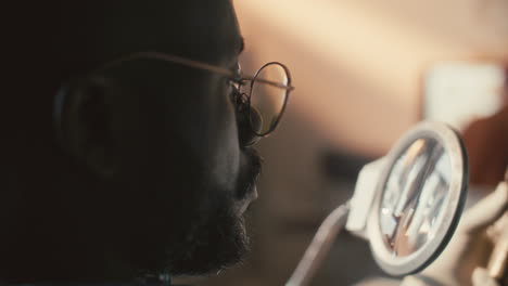 researcher inspecting spearhead under magnifying glass in laboratory