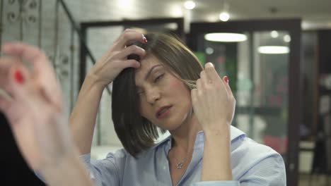 Mujer-Adulta-Con-Camisa-Mirándose-En-El-Espejo-Después-Del-Corte-De-Pelo.-Filmado-En-Cámara-Lenta