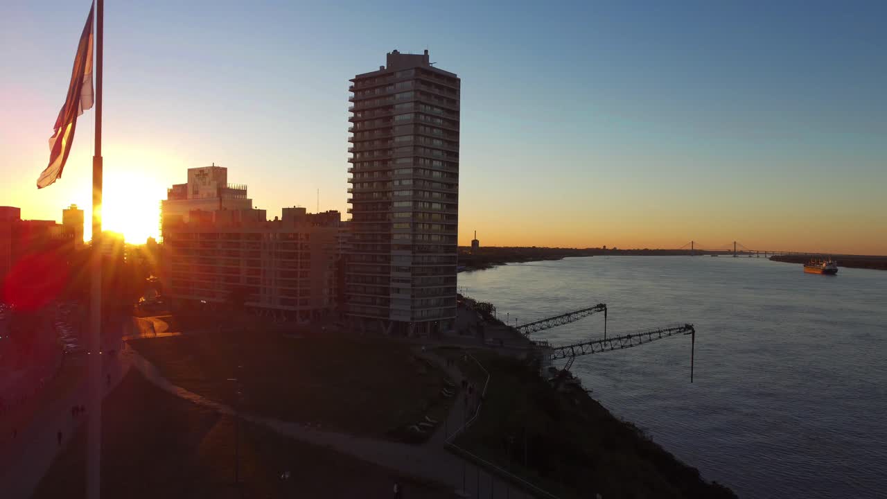 puerto norte, rosario, argentina: muelle de carga en el puerto del norte de córdoba utilizado para la carga y descarga de mercancías a lo largo del río paraná con vistas a edificios de varios pisos durante la puesta de sol