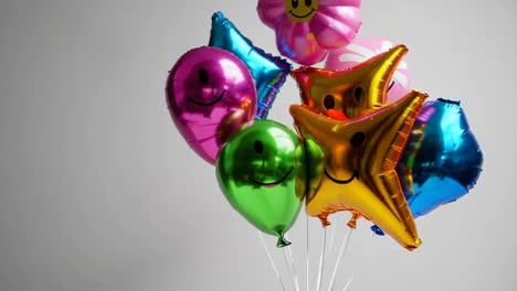colorful foil balloons with smiley faces and flower