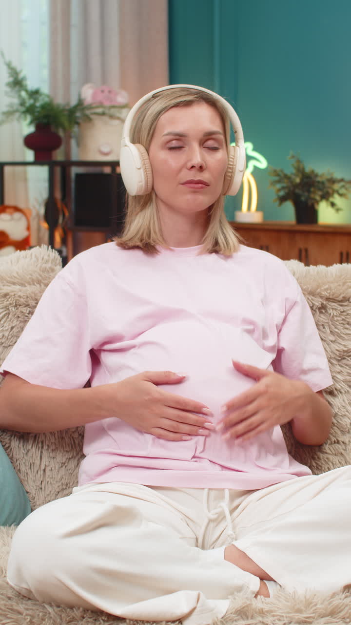 Pregnant woman meditation headphones ocean waves sound calm posture hands on belly focus balance zen