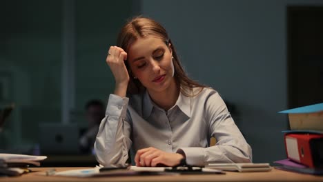 una mujer de negocios cansada en su escritorio.