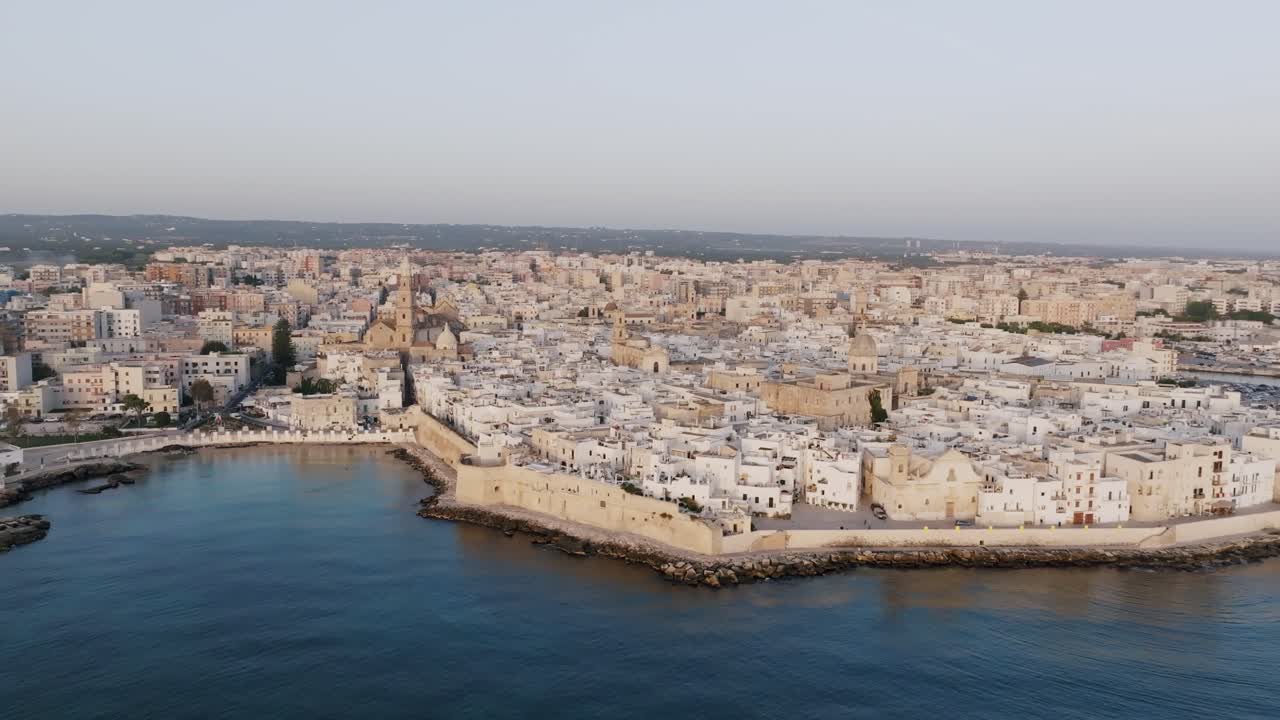 Riprese aeree che ruotano al largo della costa italiana intorno alla città di Monopoli alla luce dell'alba