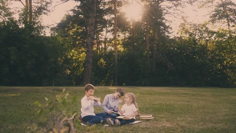 young pupils sit surrounded by books and paper sheets