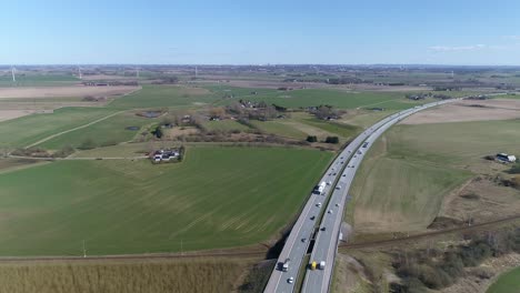 autopista e6 suecia, coches camioneros conducen a lo largo de la curva rodeado de campos verdes ondulados