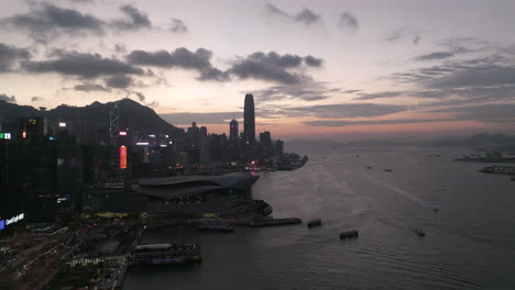 Rising-drone-shot-over-Wan-Chai-Exhibition-Centre-with-Central-financial-district-in-backdrop-after-sunset