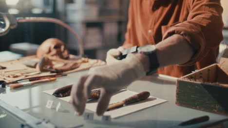 archaeologist applying labels to artifacts and taking photos with camera