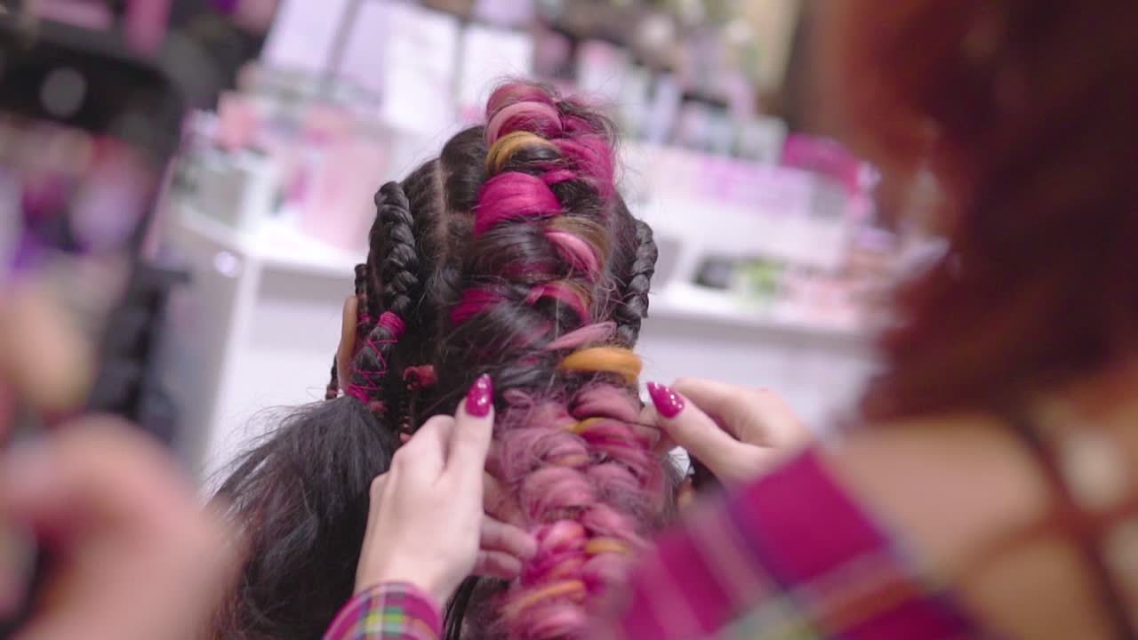 Colourful braids done by professional hairdresser finished hairstyle slow motion