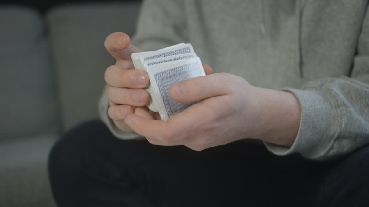 Mani maschili mescolano un mazzo di carte per una partita a poker, al rallentatore.