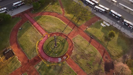 toma aérea de arriba hacia abajo del parque frente a la estación de tren de retiro con autobuses de estacionamiento