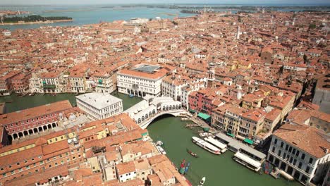 rialto bridge in venice, italy, aerial view above grand canal, city, gondolas and boats sailing in the summer european destination at adriatic sea