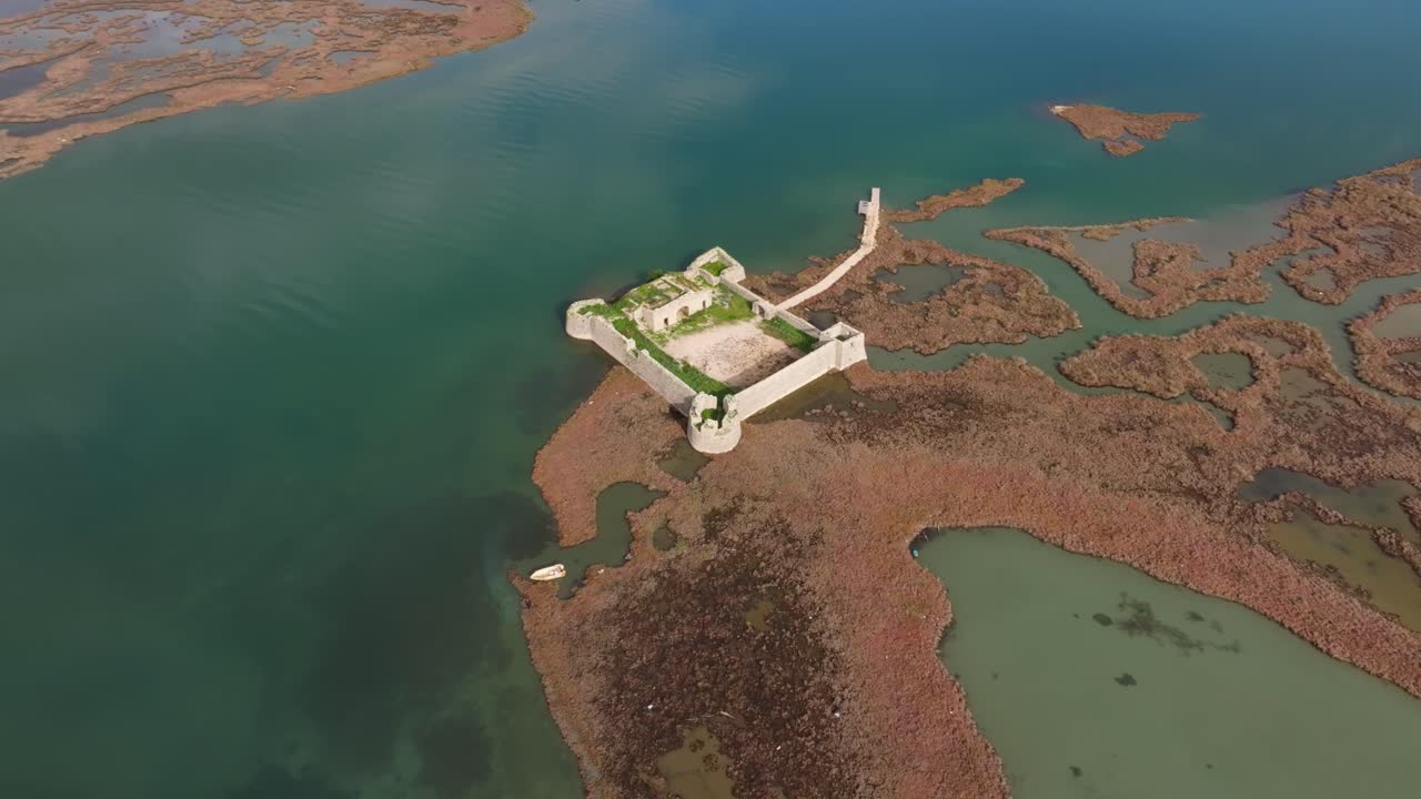 Vista drone di una rovina di castello che si fonde con il paesaggio, Ksamil