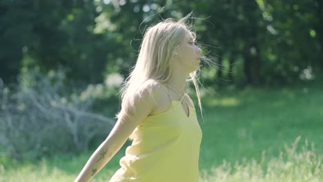 mujer con vestido amarillo bailando con gracia en el parque de verano