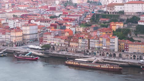 Porto,-Portugal,-Unesco-Heritage-Site,-old-city-houses-and-Douro-river-with-boats-during-sunrise-blue-hour-timelapse