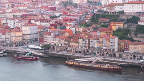 porto, portugal, unesco heritage site, old city houses and douro river with boats during sunrise blue hour timelapse