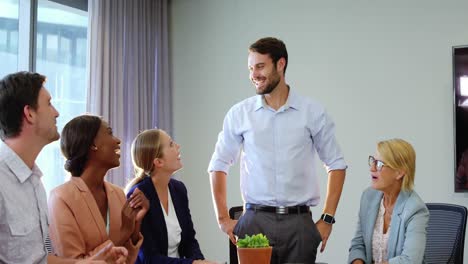 hombres de negocios interactuando y aplaudiendo a un compañero de trabajo
