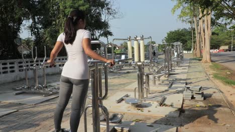 Una-Mujer-Que-Trabaja-En-Un-Gimnasio-Al-Aire-Libre-Haciendo-Ejercicio-Y-Tonificando-Sus-Caderas-Y-Muslos---Plano-General-Detrás-De-La-Chica