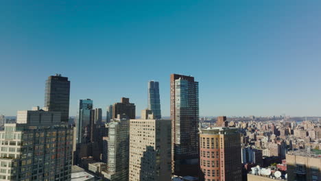 Los-Delanteros-Vuelan-Sobre-La-Ciudad.-Edificios-De-Apartamentos-Altos-Contra-El-Cielo-Azul-Claro-En-Un-Día-Soleado.-Manhattan,-Ciudad-De-Nueva-York,-Estados-Unidos