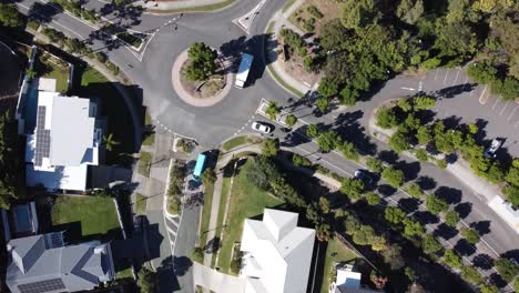 vista aérea de una rotonda suburbana en australia con camiones y coches