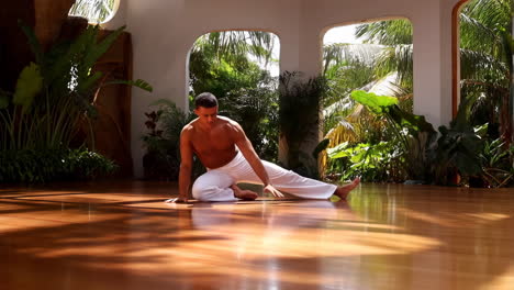 man practicing yoga or fitness in a bright studio with tropical views
