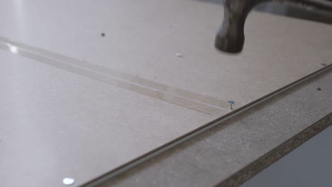 slow motion close up of hammering a nail into the back of a wardrobe from ikea