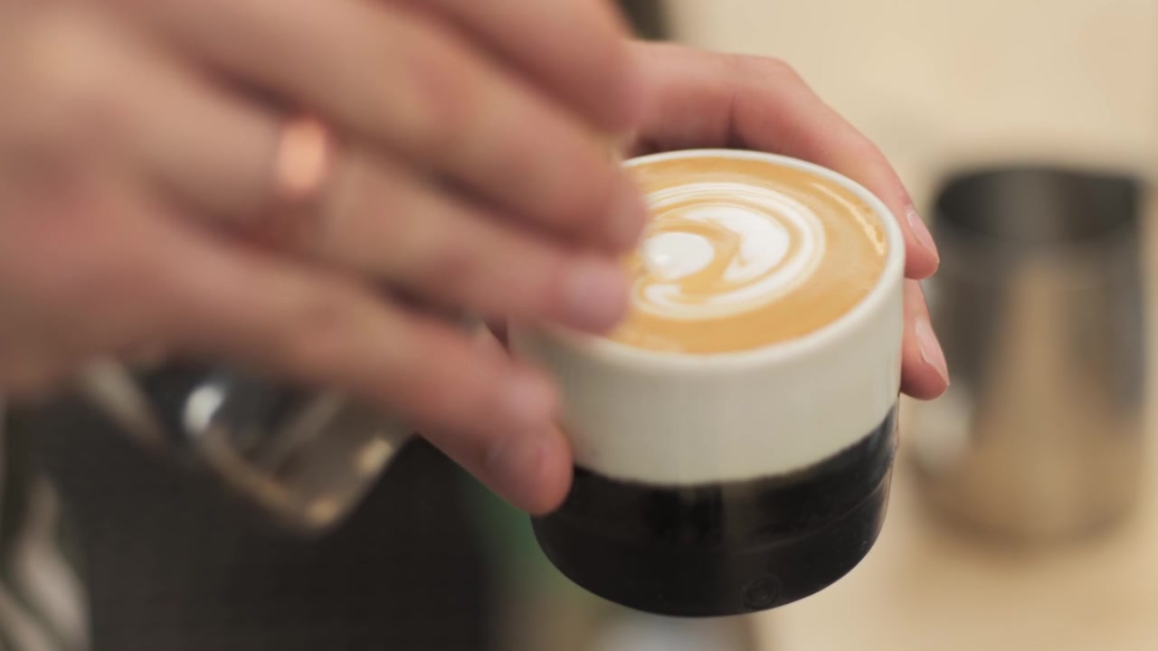 Un Flat white completato con latte art a forma di fiorellino
