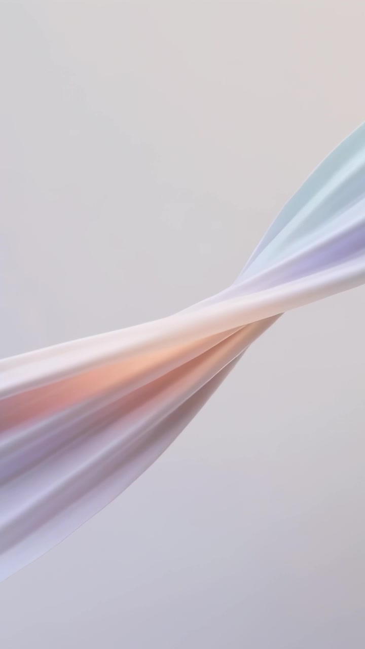 Video vertical: Tela de seda flotando retorciéndose en el estudio, llevada por la brisa revelando tonos pastel.