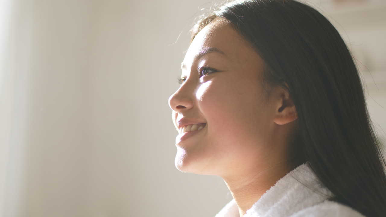 Happy Young Woman in Bathrobe