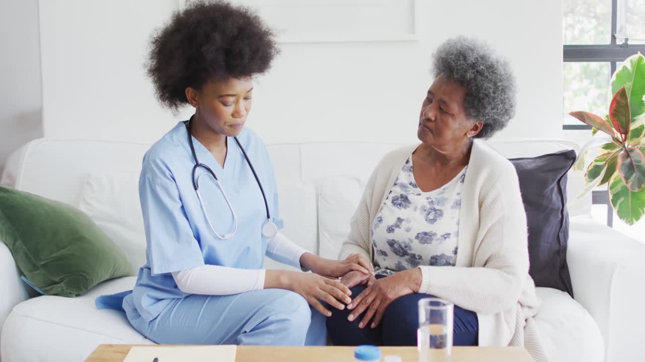 Femme médecin afro-américaine mécontente et femme âgée triste discutant.