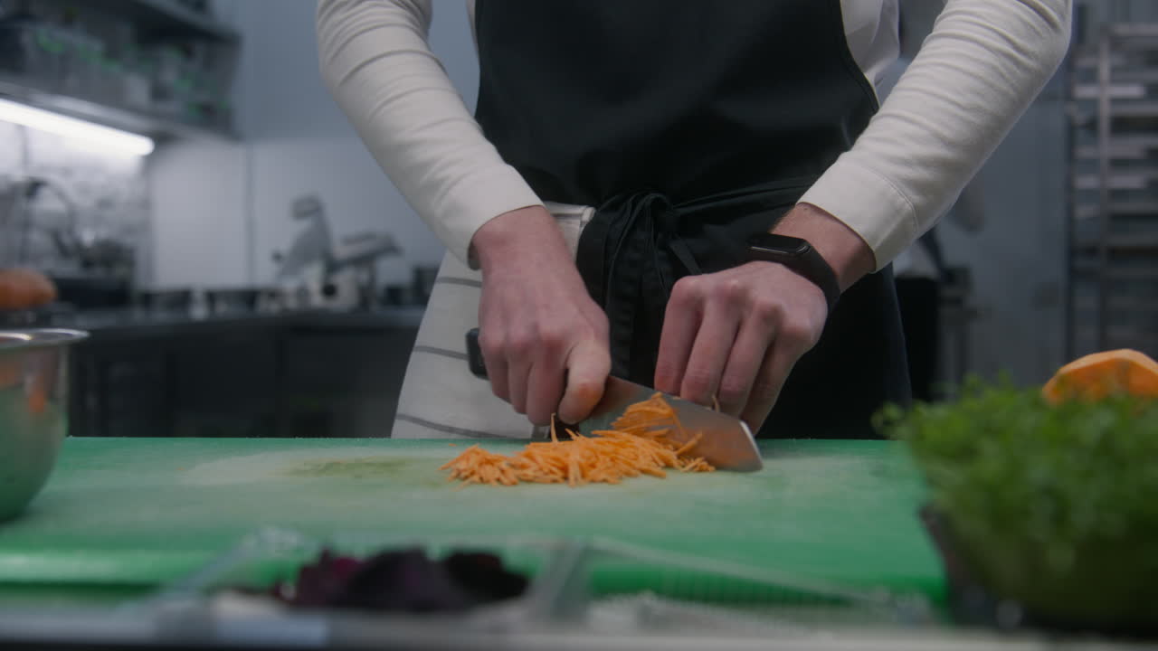 Chef Chopping Carrots in a Kitchen