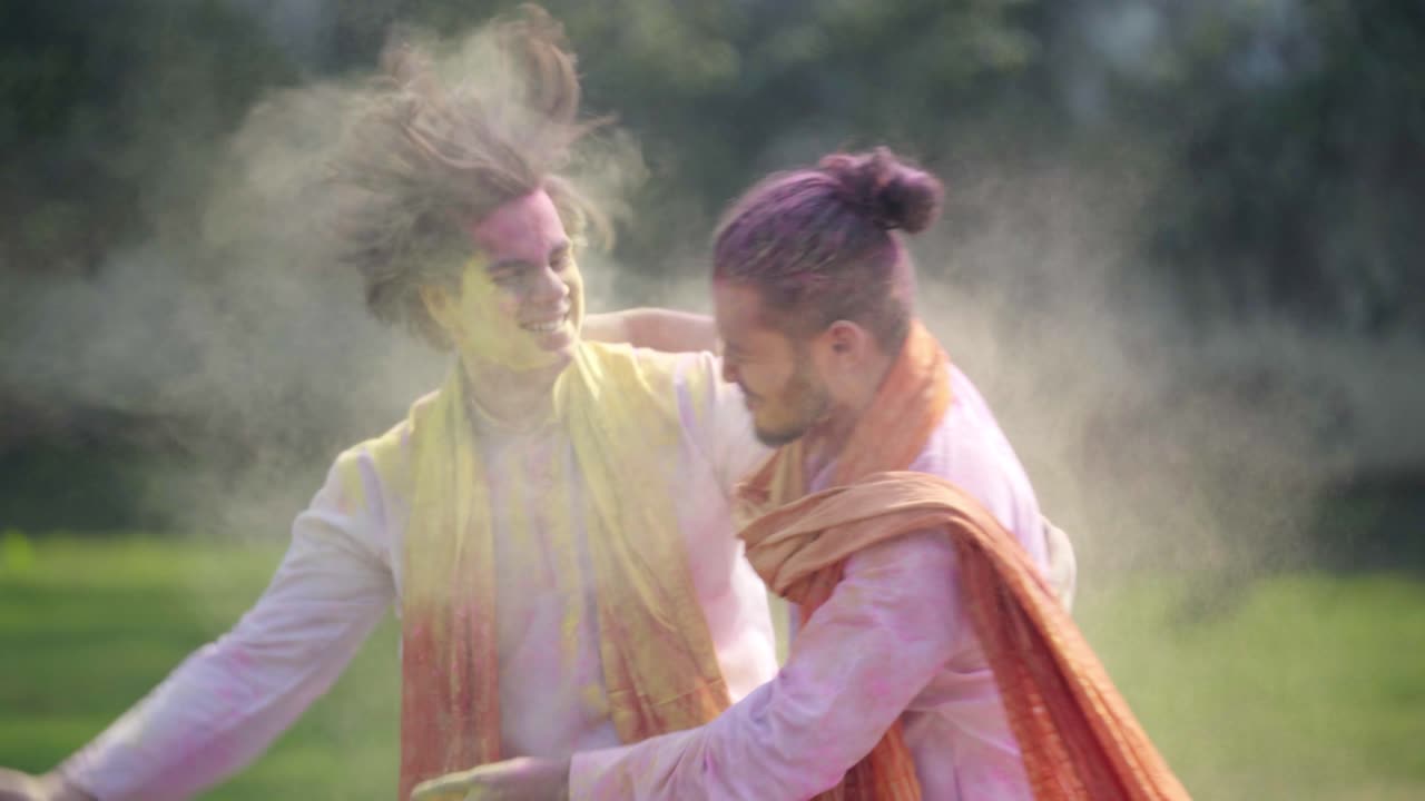 Uomini indiani che si mettono i colori Holi in faccia