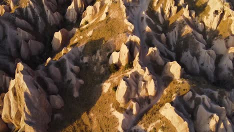 Aerial-shot-of-Cappadocia-during-golden-hour,-revealling-entire-mountain-and-wide-landscape