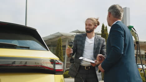 el hombre de negocios discute las opciones de carga de ev