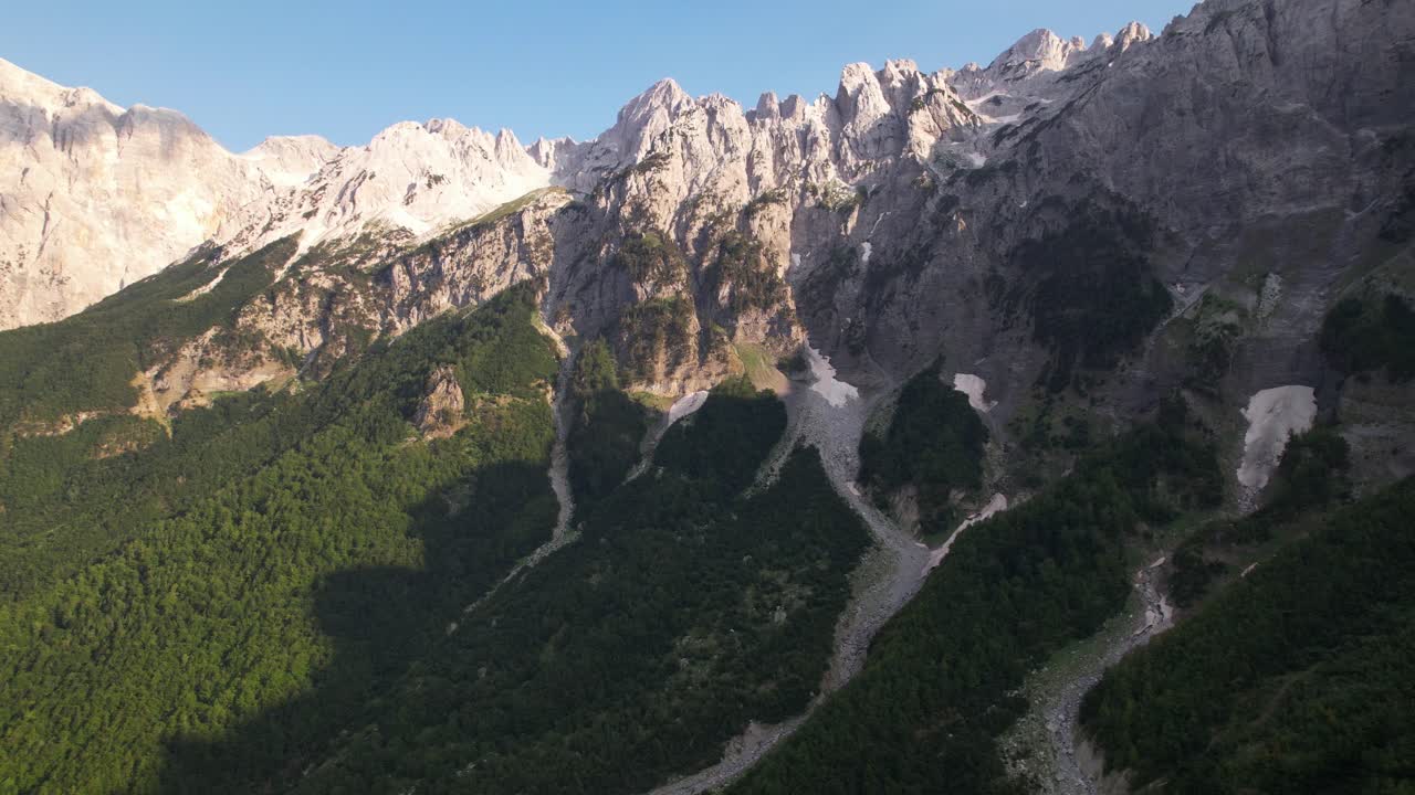 hermosas montañas en los alpes de albania con altos picos rocosos, formas de nieve blanca y bosque verde