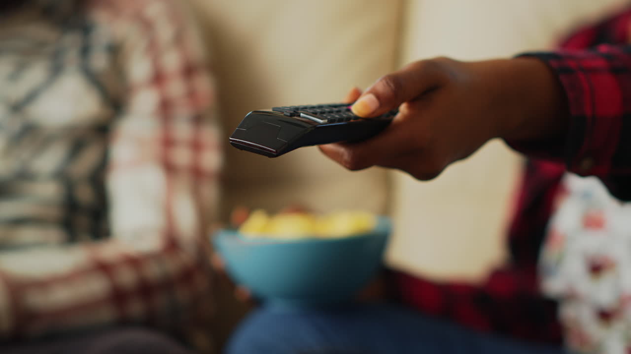Woman switching channels with tv remote control