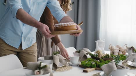 Caucasian-couple-preparing--table-for-easter-dinner.