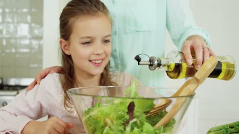 Mother-assisting-daughter-in-preparing-salad