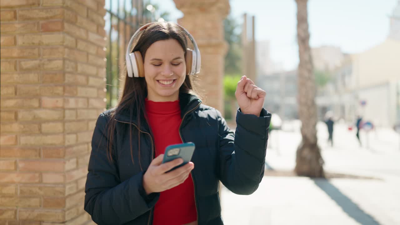 mujer joven sonriendo confiada escuchando música en la calle