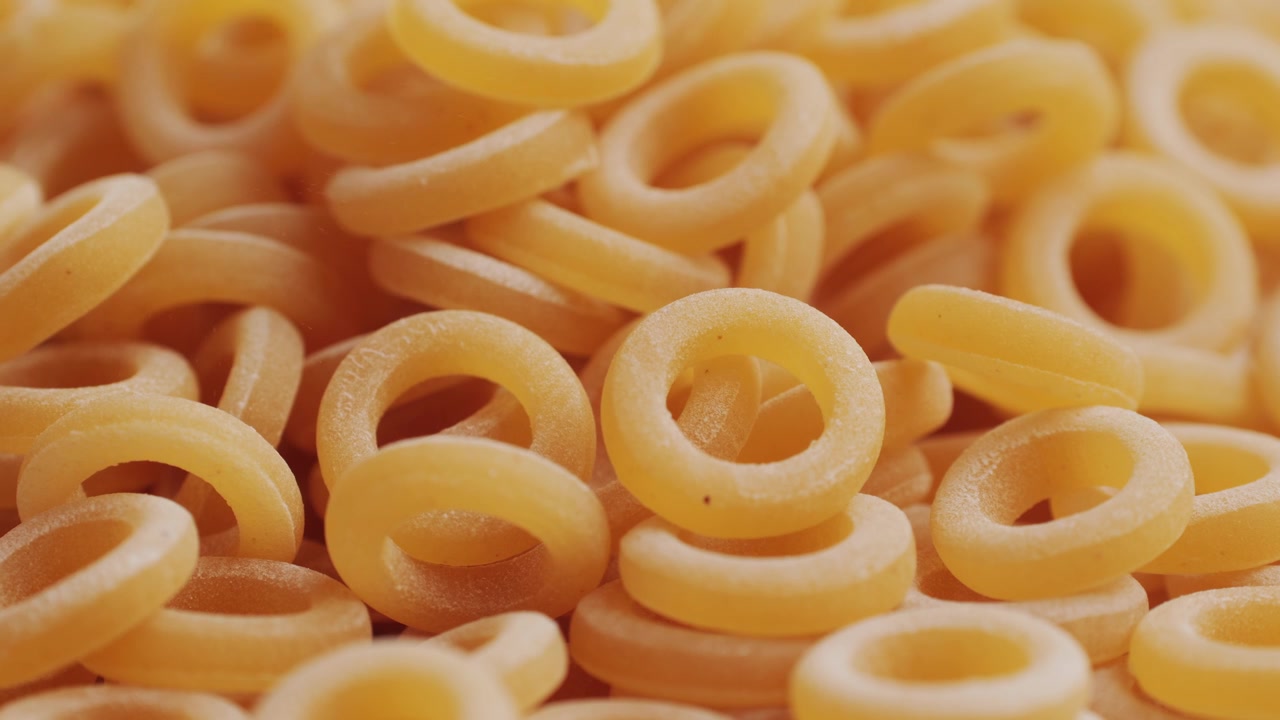 Pasta integrale biologica, maccheroni di semola di grano duro, penne rigate crude in una ciotola di legno. Filmato 4k di alta qualità