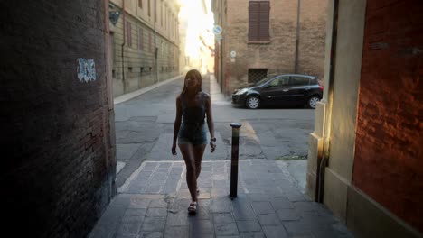 woman walking down a narrow italian street at sunset